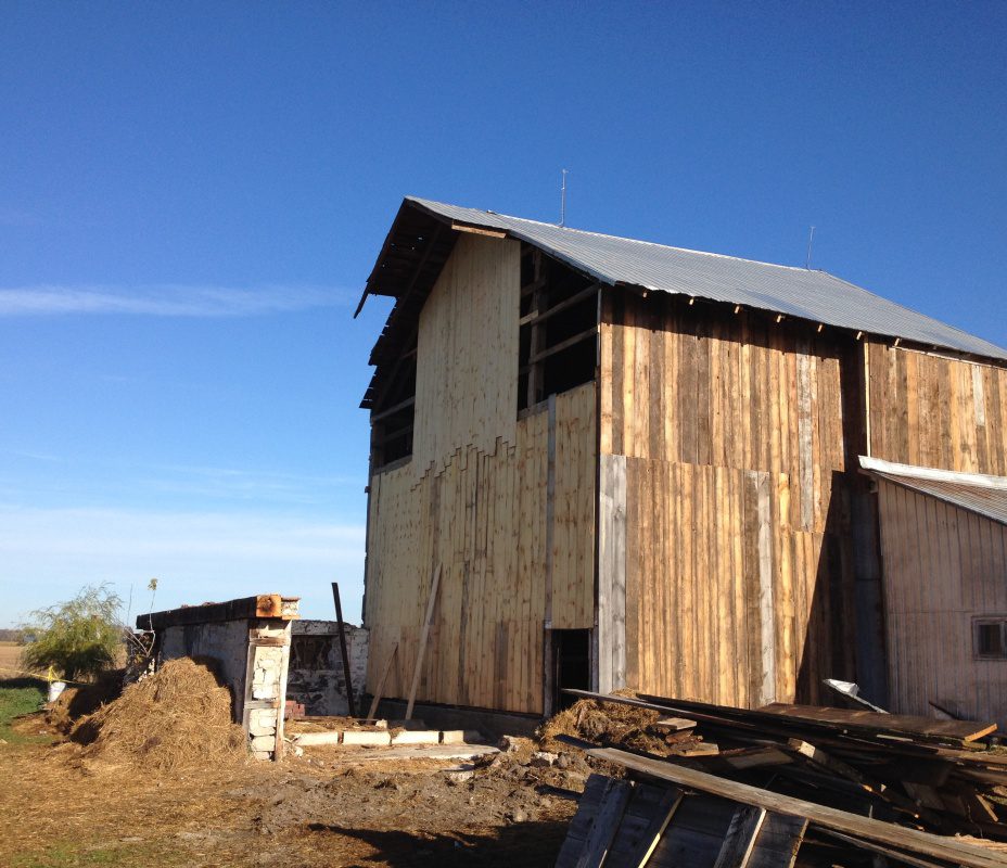 A barn with wood siding and a wooden door.