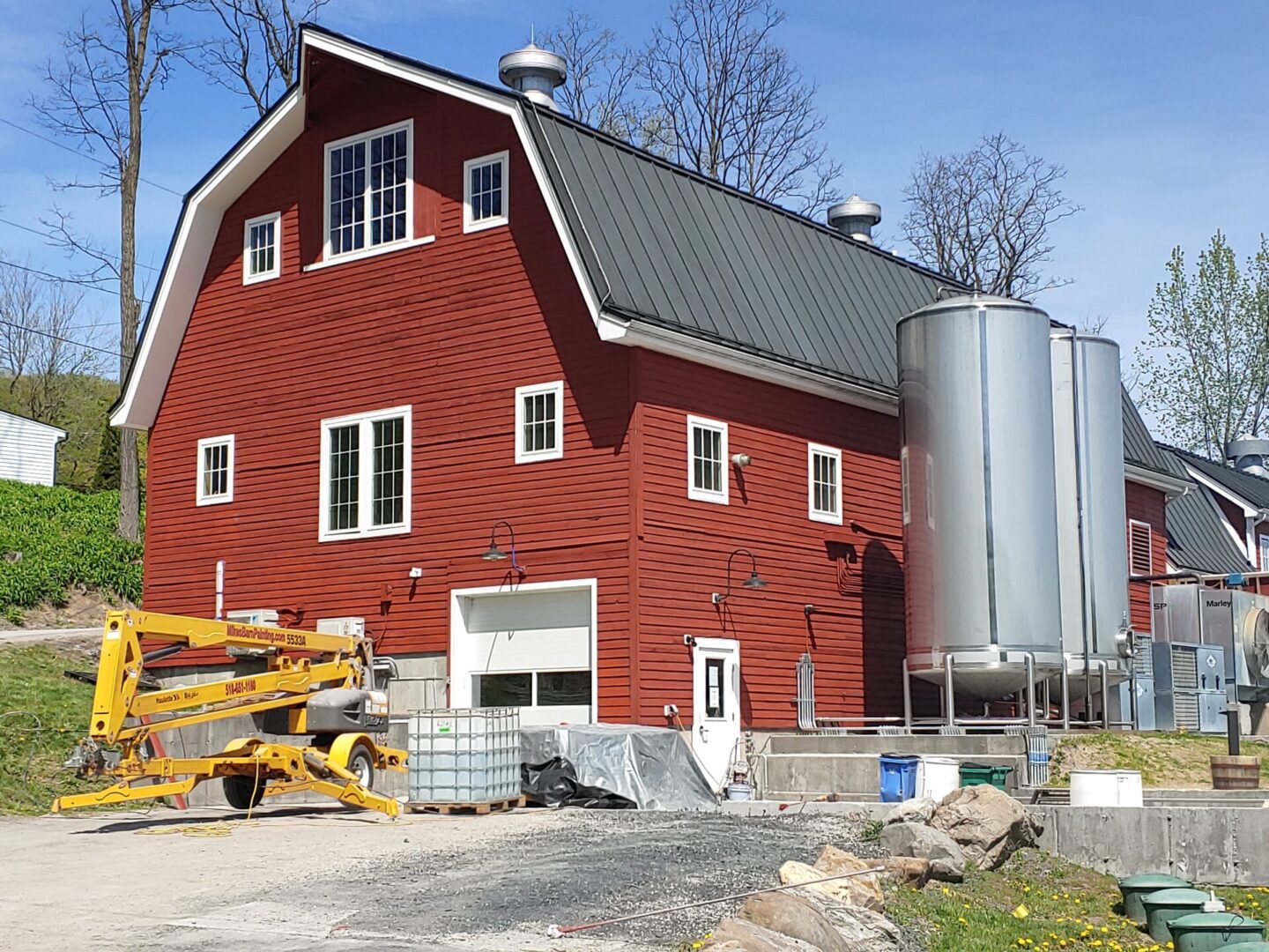 A red barn with a large silo in the background.