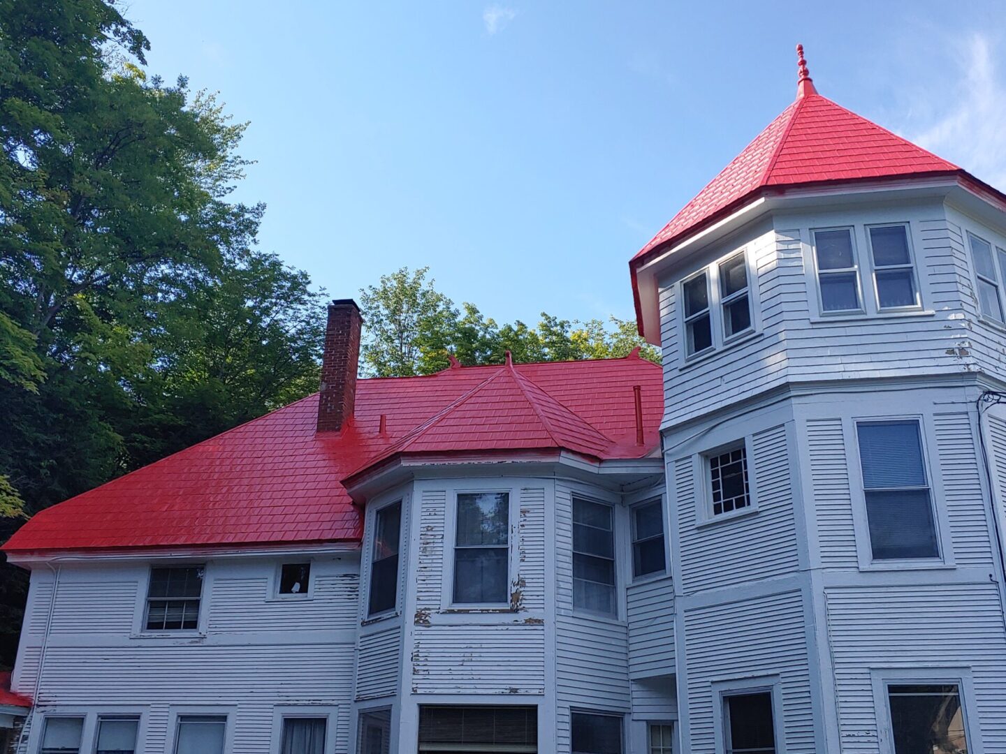 A large white house with red roof and windows.